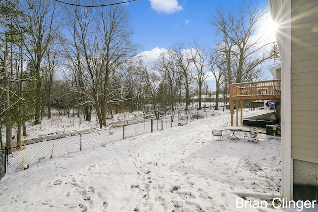 yard layered in snow featuring a deck