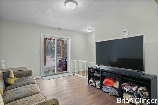 living room with hardwood / wood-style floors and a textured ceiling