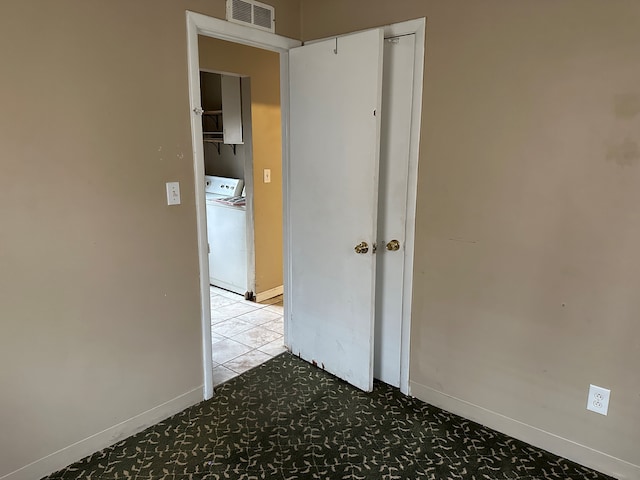 hall featuring washer / dryer and light tile patterned floors