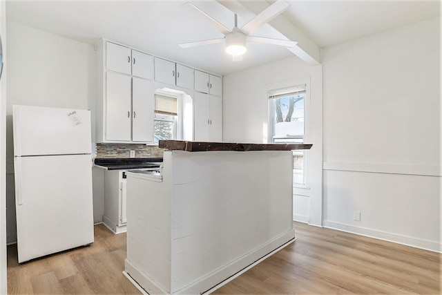 kitchen featuring white cabinets, white refrigerator, ceiling fan, tasteful backsplash, and light hardwood / wood-style floors