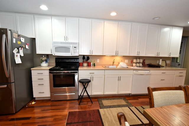 kitchen featuring appliances with stainless steel finishes, dark hardwood / wood-style flooring, sink, and white cabinets