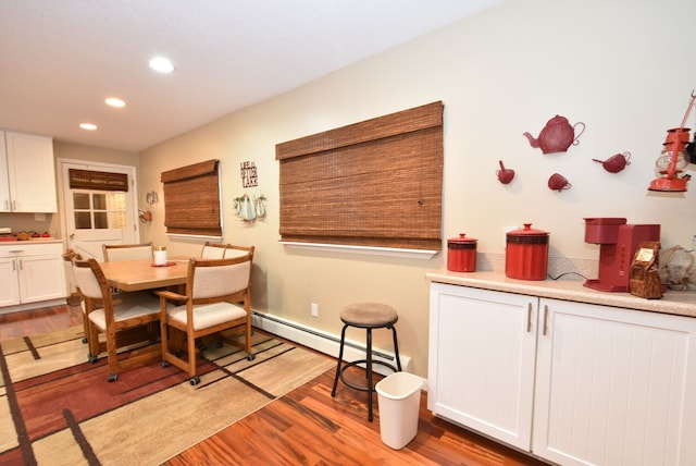 dining area featuring a baseboard radiator and light hardwood / wood-style floors