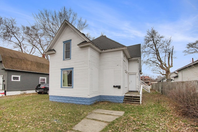 rear view of property featuring a lawn