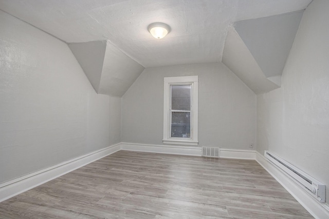 596 Superior St, Benton Harbor, MI 49022 - additional living space featuring baseboard heating, vaulted ceiling, and wood finished floors