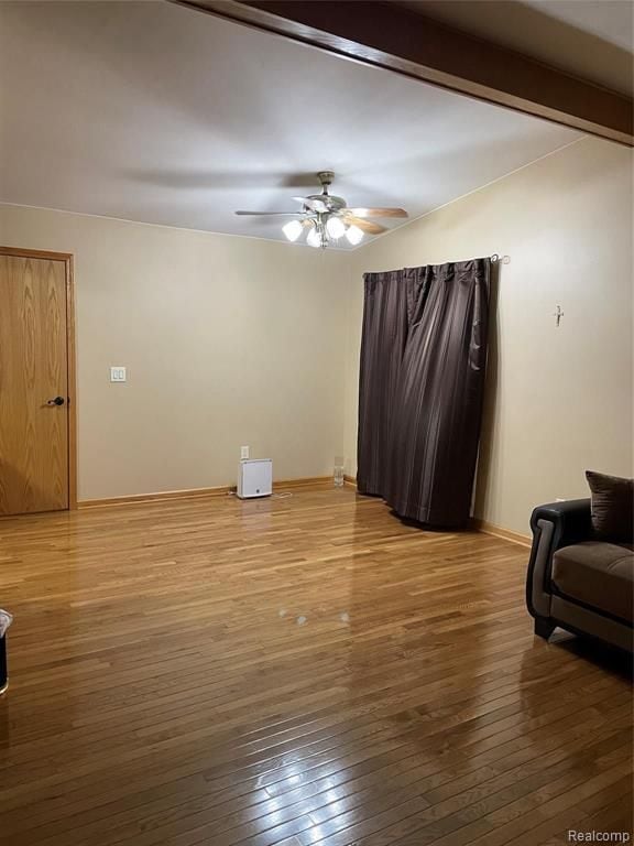 living room featuring beam ceiling, ceiling fan, and wood-type flooring