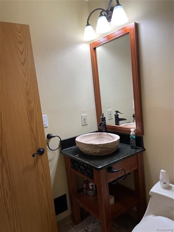 bathroom featuring tile patterned floors, vanity, and toilet