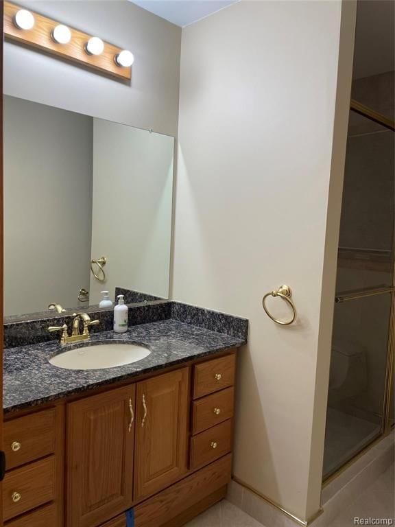 bathroom with a shower with door and vanity