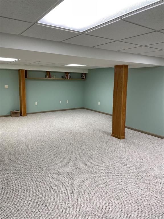 basement with carpet flooring and a paneled ceiling