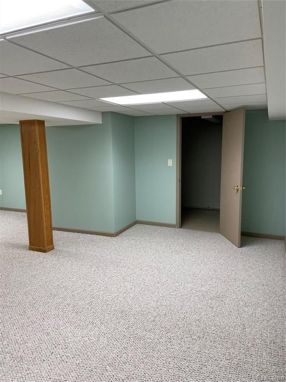 basement with a drop ceiling and carpet floors