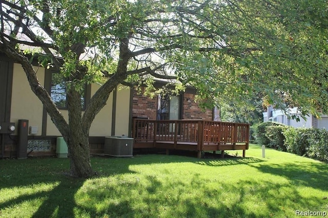 view of yard featuring a deck and central air condition unit