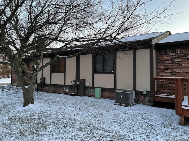 view of snowy exterior featuring central air condition unit