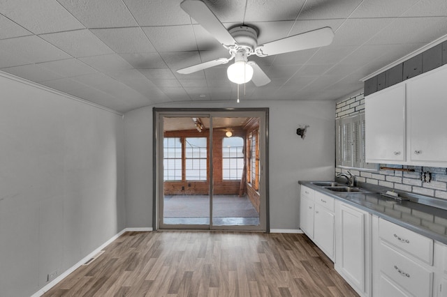 kitchen with sink, ceiling fan, tasteful backsplash, light hardwood / wood-style floors, and white cabinetry