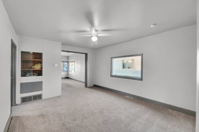 carpeted spare room with ceiling fan