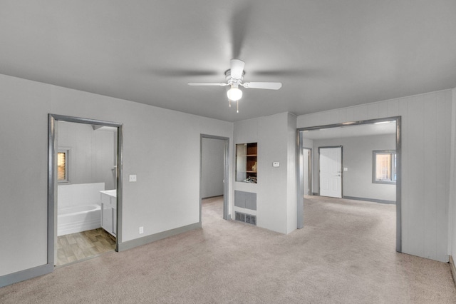 unfurnished bedroom with light colored carpet, ceiling fan, and ensuite bathroom