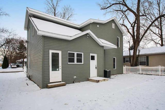 snow covered house with central air condition unit