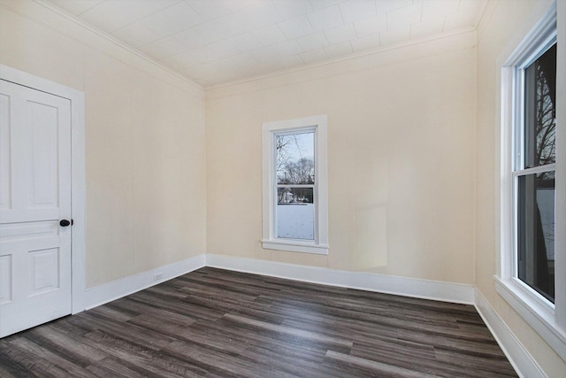 empty room with dark hardwood / wood-style flooring and ornamental molding