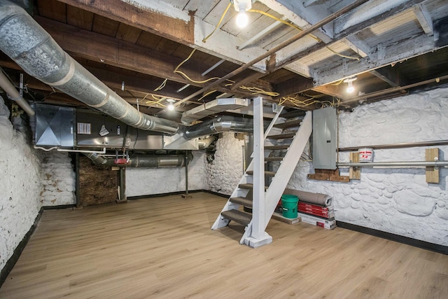 basement with hardwood / wood-style floors and electric panel