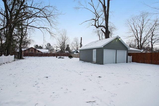 yard covered in snow featuring a garage and an outdoor structure