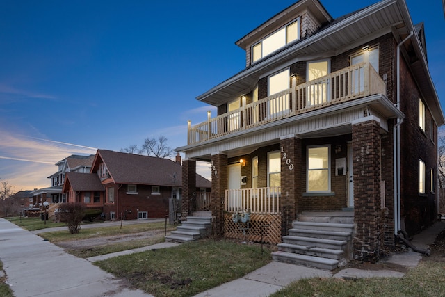 view of front of property with covered porch and a balcony