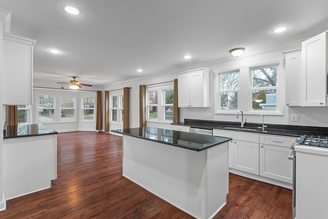 kitchen featuring white cabinetry, stove, a kitchen island, and ceiling fan