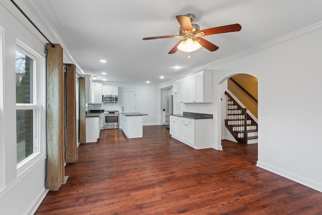 kitchen with white cabinets, ornamental molding, and stainless steel appliances