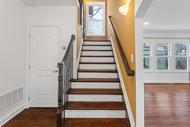 staircase featuring a healthy amount of sunlight and wood-type flooring