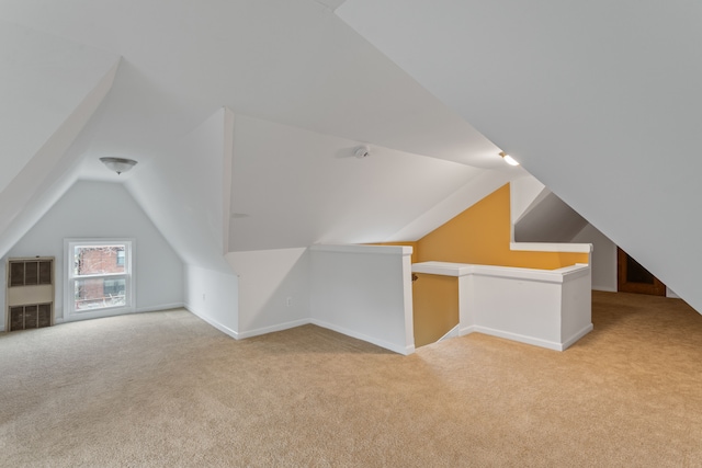 bonus room featuring lofted ceiling, light carpet, and heating unit