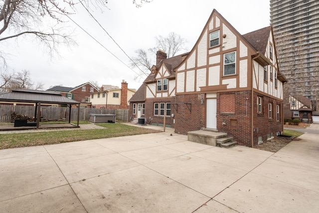 rear view of house featuring a patio area, a hot tub, and central AC