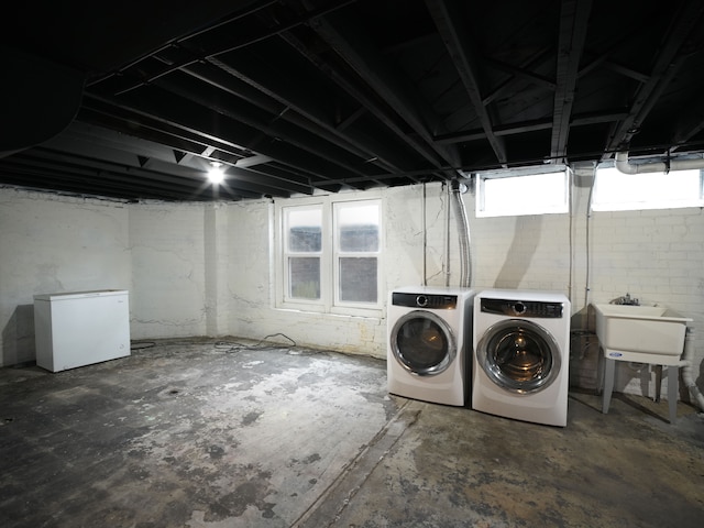 basement with washer and clothes dryer, refrigerator, and sink