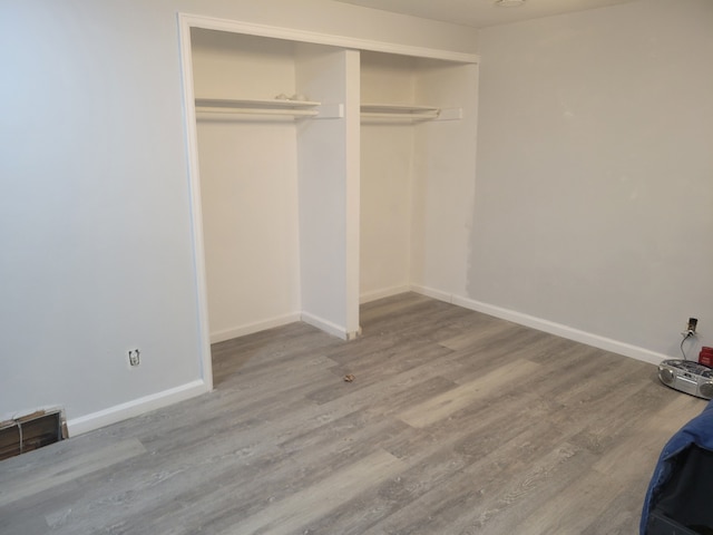 unfurnished bedroom with hardwood / wood-style flooring and a closet