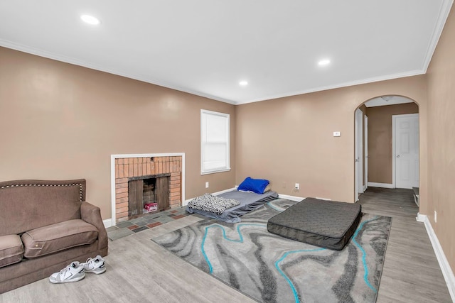 living room featuring a fireplace, ornamental molding, and light wood-type flooring