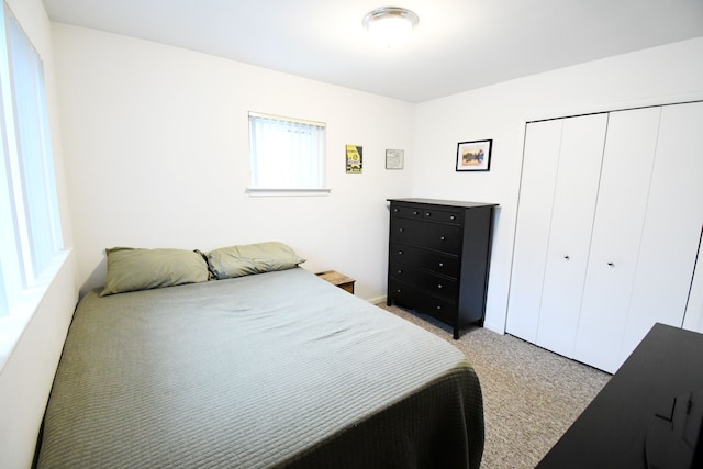 bedroom featuring light carpet and a closet