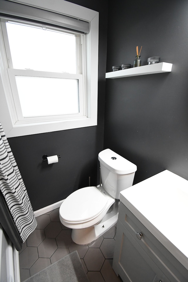 bathroom featuring tile patterned flooring, vanity, and toilet