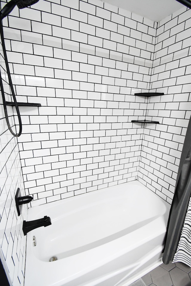 bathroom featuring tile patterned flooring and tiled shower / bath combo