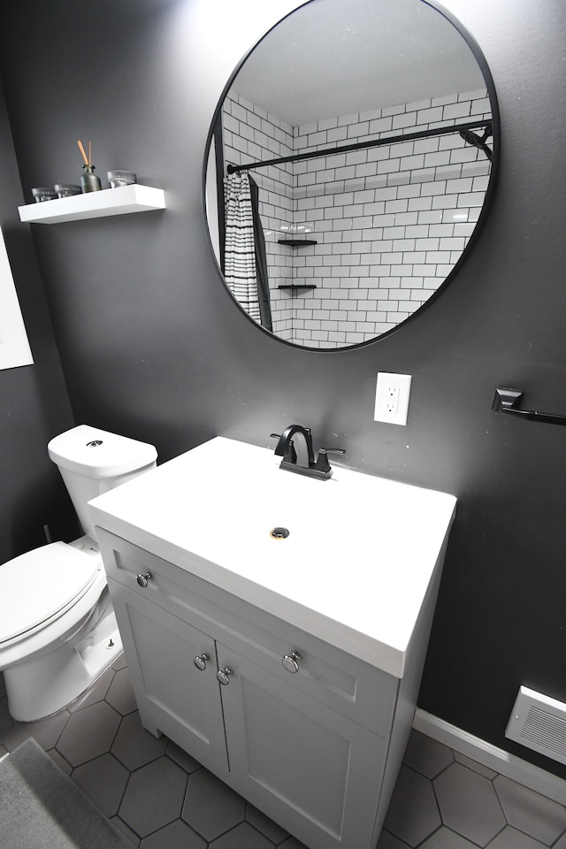 bathroom featuring tile patterned flooring, vanity, and toilet