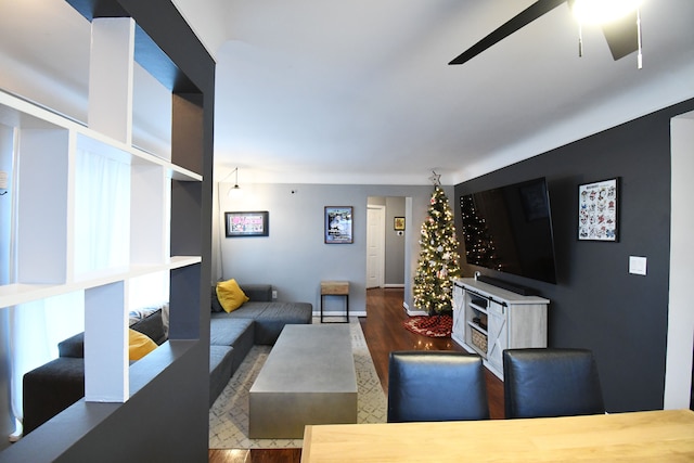 living room featuring ceiling fan and dark wood-type flooring