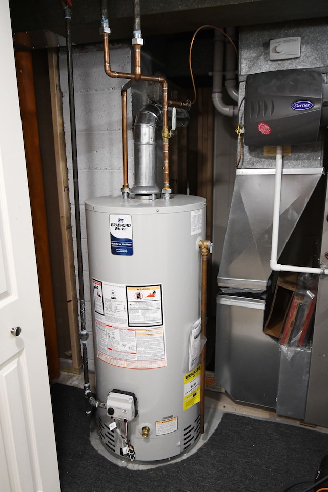 utility room featuring heating unit and water heater