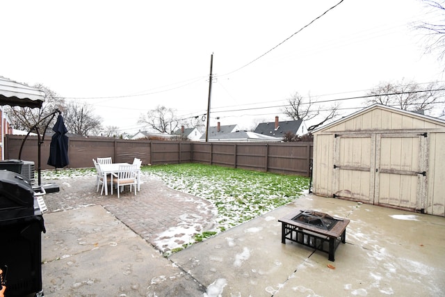 view of patio / terrace with central AC, an outdoor fire pit, a storage shed, and a grill