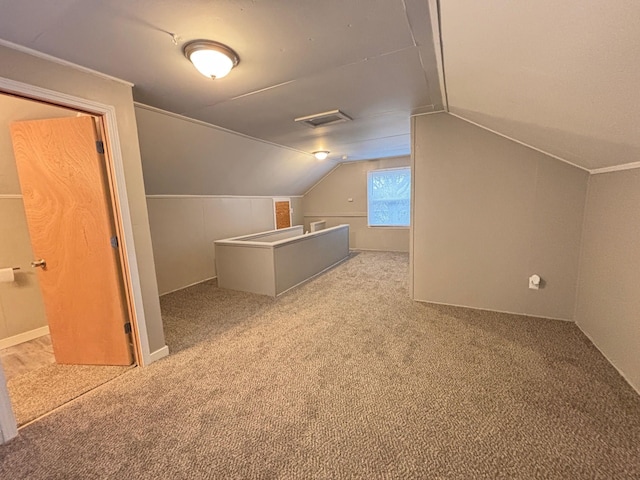 bonus room with lofted ceiling and light carpet