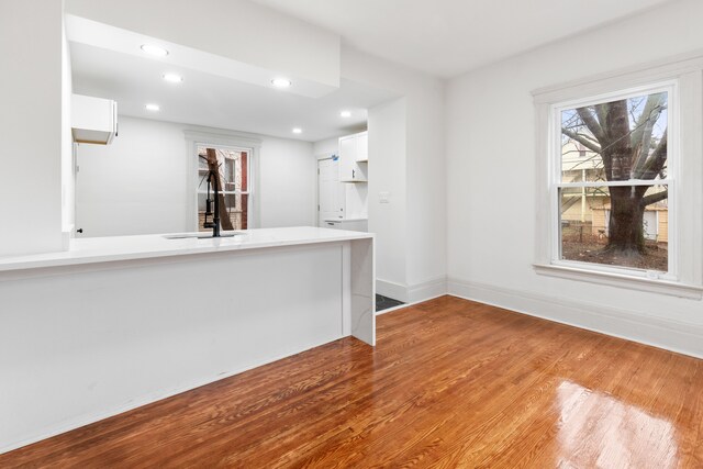 bar with white cabinets, sink, and hardwood / wood-style floors