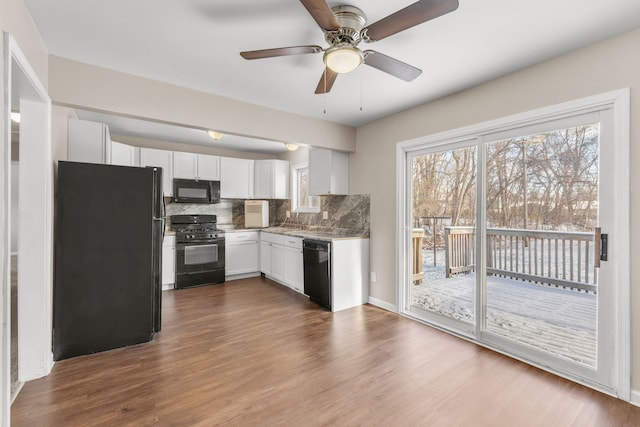 kitchen featuring ceiling fan, tasteful backsplash, wood-type flooring, white cabinets, and black appliances