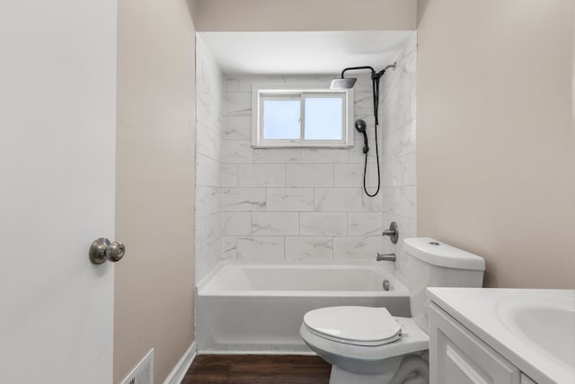 full bathroom featuring hardwood / wood-style floors, vanity, toilet, and tiled shower / bath combo