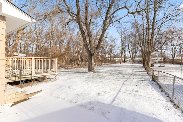 yard covered in snow featuring a deck