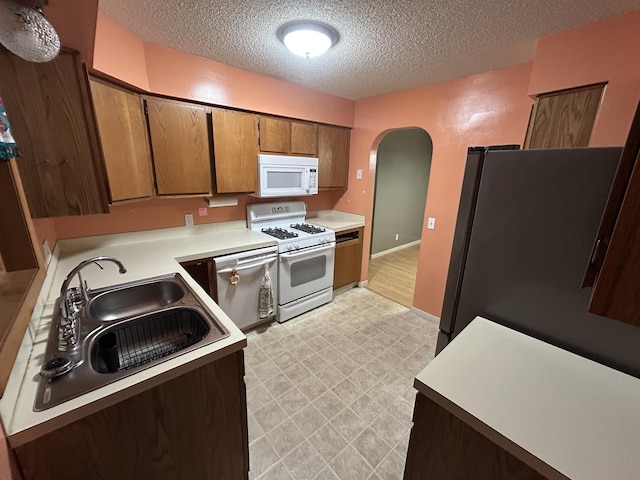 kitchen with sink, a textured ceiling, and appliances with stainless steel finishes