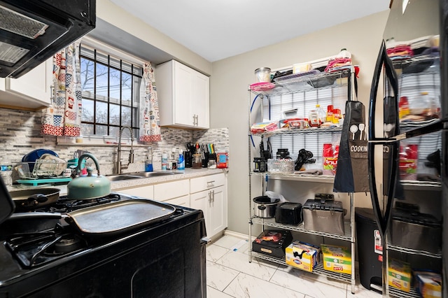 kitchen featuring decorative backsplash, sink, white cabinetry, and black appliances