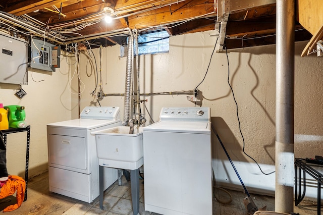 laundry area featuring sink, electric panel, and washing machine and clothes dryer