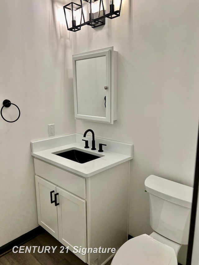 bathroom featuring vanity, wood-type flooring, and toilet