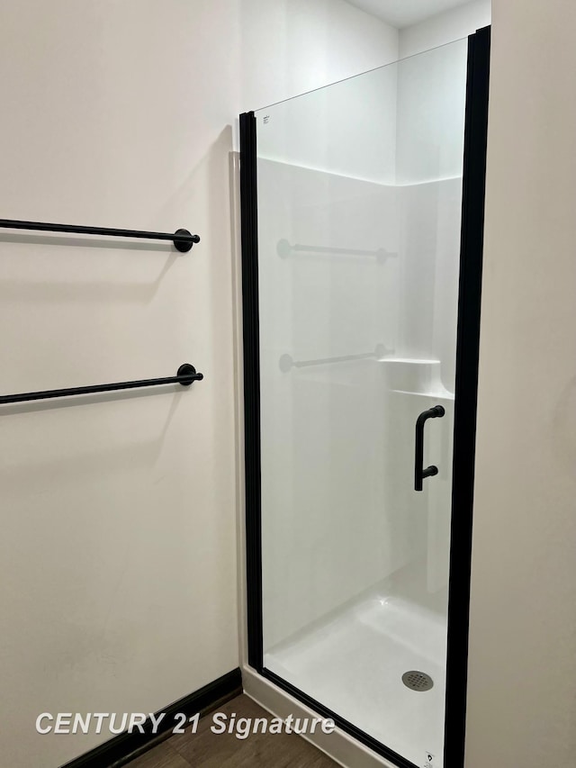 bathroom with wood-type flooring and walk in shower