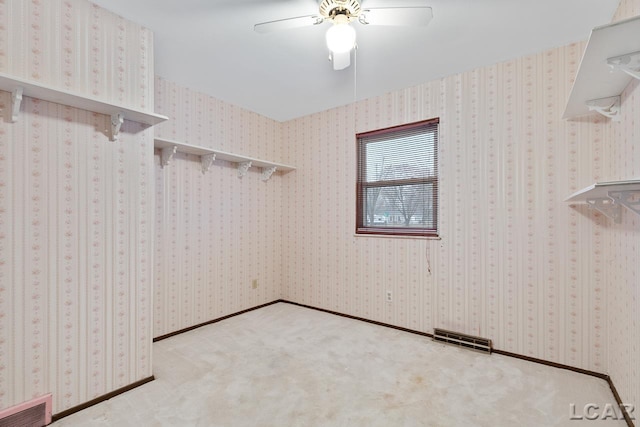 spacious closet with ceiling fan and light colored carpet