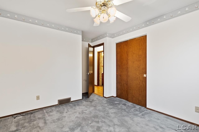 unfurnished bedroom featuring ceiling fan, a closet, and carpet